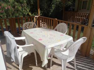 een witte tafel en stoelen op een patio met een tafel en stoelen bij MOBIL HOME 3 Chambres Climatisé au CAMPING DES ISCLES in La Roque-dʼAnthéron