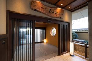 an entrance to a building with a sign on the wall at Kyoto Umekoji Kadensho in Kyoto