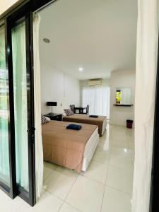 Wassana Sitdharma Guesthouse في Ban Na Pho: غرفة نوم مع سرير وغرفة معيشة