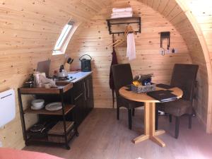 a small kitchen with a table in a tiny house at Scallow Campsite in Lewes