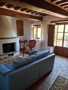salon z niebieską kanapą i telewizorem w obiekcie Villa Le Ginestre w mieście Cortona
