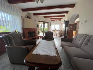 ein Wohnzimmer mit einem Tisch und Sofas in der Unterkunft Willa Garden 2 z pięknym ogrodem i tarasem in Ustronie Morskie