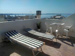 a balcony with two benches and a table and chairs at La Fontana in Gallipoli