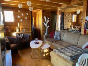 ein Wohnzimmer mit einem Sofa und einem Tisch in der Unterkunft Chalet confortable vue panoramique in Isola 2000