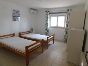 two beds in a room with a window at Villa 54 - Plage Aiguebelle 250m in Le Lavandou