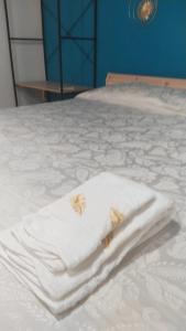 una pila de toallas sentadas encima de una cama en Casetta Santa Maria Degli Angeli, en Santa Maria degli Angeli