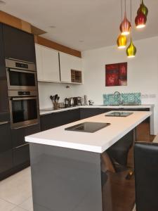 uma cozinha com um balcão branco e electrodomésticos pretos em Ard Kielin Apartment Luxury 2 bedroom in Killarney em Killarney