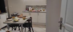 a small kitchen with a table with chairs and a counter at Les plaisirs de la ruralité in Vendresse +4 photos