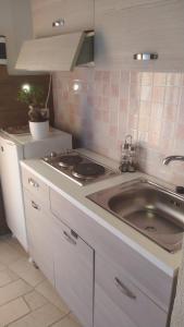 a kitchen with a sink and a stove at Casetta Santa Maria Degli Angeli in Santa Maria degli Angeli