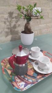 d'une table avec une théière, des tasses et une plante dans l'établissement Casetta Santa Maria Degli Angeli, à Santa Maria degli Angeli