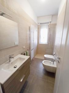 uma casa de banho branca com um lavatório e um WC em Appartamento Bellavista em Ventimiglia