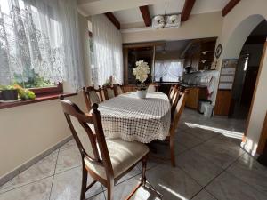 jadalnia ze stołem i krzesłami oraz kuchnia w obiekcie Willa Garden 2 z pięknym ogrodem i tarasem w mieście Ustronie Morskie