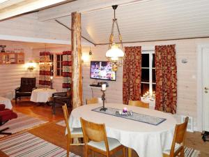 sala de estar con mesa, sillas y TV en Two-Bedroom Holiday home in Laupstad 5, en Vestpollen