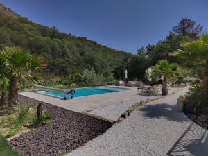 a swimming pool with a slide next to a mountain at Villa les trois J in Grimaud