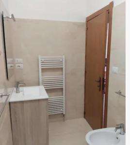 ein Badezimmer mit einem Waschbecken, einem WC und einem Spiegel in der Unterkunft Casa Stella in Uggiano la Chiesa
