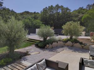 einen Garten mit zwei Bäumen und einer Bank in der Unterkunft Villa les trois J in Grimaud