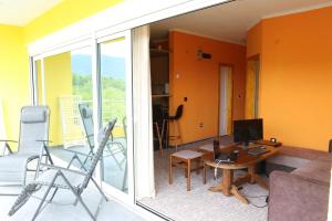 a living room with a table and a computer on a balcony at Crypto Hills Montenegro in Herceg-Novi
