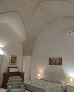 ein Schlafzimmer mit einem Bett und einem Stuhl in einem Zimmer in der Unterkunft Casa Stella in Uggiano la Chiesa