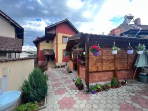 une maison avec une clôture et des fleurs dans une cour dans l'établissement Casa Flori, à Călimăneşti