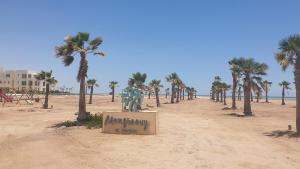 a statue of a man on the beach with palm trees at Elgouna Heart Mangroovy new 2bedrooms in Hurghada