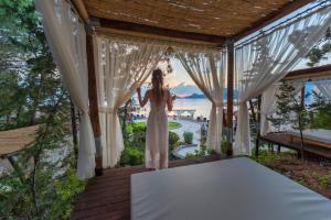 a woman in a white dress standing on a porch at Liberty Lykia Adults Only in Oludeniz +37 photos