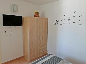 a bedroom with a wooden cabinet with butterflies on the wall at Apartment Ivana in Baška