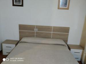 a bed in a room with two nightstands and a bed sidx sidx sidx at Hostal Fisterra in Lugo