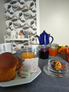 uma mesa com um prato de pão e sumo de laranja em Le crabe rouge em Groix