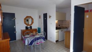 uma pequena cozinha com uma mesa e um espelho em Joli T2 vue mer, proche mer, parking, Narbonne-plage em Narbonne Plage