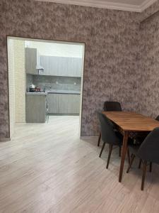 a dining room with a table and chairs and a kitchen at Levent Beach Apartment in Sumqayıt
