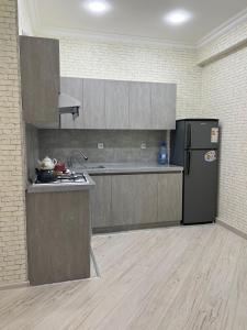 a kitchen with a refrigerator and a counter top at Levent Beach Apartment in Sumqayıt