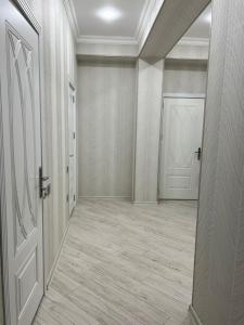 an empty hallway with a white door and a room at Levent Beach Apartment in Sumqayıt