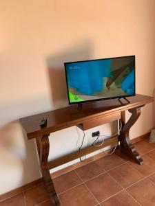 TV de pantalla plana sobre una mesa de madera en Villa Paradiso, en Montegiordano