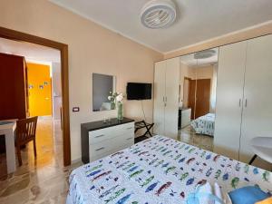 a bedroom with a bed and a desk and a television at La Fresia Bianca in Sciacca