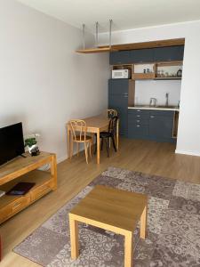 sala de estar con mesa y cocina en KURESSAARE TALLINN STREET APARTMENTs, en Kuressaare