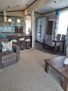 cocina y sala de estar con sofá y mesa en Pemberton Arrondale Lodge, Lakeside View (Haven Lakeland), en Flookburgh