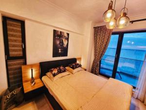 een slaapkamer met een bed en een groot raam bij Deluxe Lake View in Mamaia