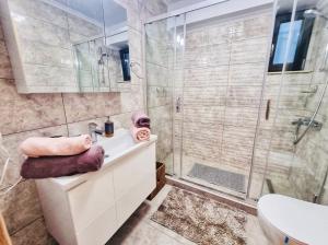 een badkamer met douche, wastafel en toilet bij Deluxe Lake View in Mamaia +40 foto's