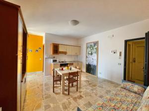 a living room with a table and a kitchen at La Fresia Bianca in Sciacca