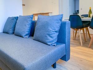 - un canapé bleu avec 2 oreillers dans l'établissement Ambiance Cosy, à Buxy