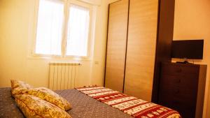a bedroom with a bed with a television and a window at La Casetta B&B in Cernusco sul Naviglio