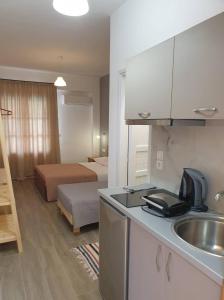 a kitchen with a sink and a room with a bed at Apart-Hotel Llazari in Himare