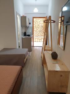 a room with two beds and a kitchen with a door at Apart-Hotel Llazari in Himare