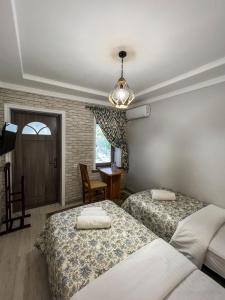 um quarto com 2 camas, uma mesa e uma janela em East House em Samarkand