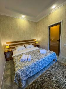 um quarto com uma cama grande com duas toalhas em East House em Samarkand