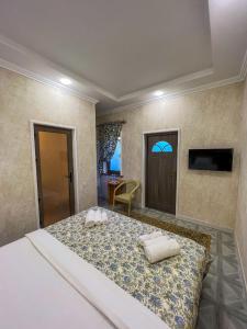 um quarto com uma cama grande com duas almofadas em East House em Samarkand