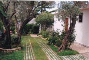 een tuin met bomen en een wit huis bij Family apartment with terrace in Cres
