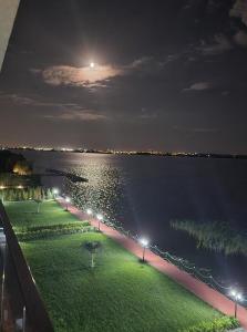 een uitzicht op het water 's nachts met de maan bij Deluxe Lake View in Mamaia