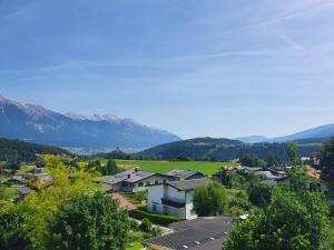 a town with houses and a green field and mountains at Ferienwohnung Sophia in Innsbruck