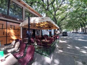 a restaurant with tables and chairs on the street at Bed&Breakfast INTERMEZZO CAFFE in Kikinda